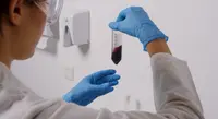 Lab analyst holding up a water sample