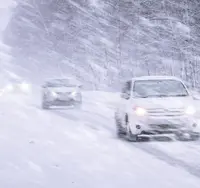 Cars driving through heavy snowfall