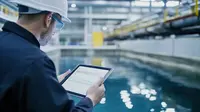 Engineer with a tablet at a water treatment basin